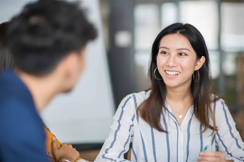 Two colleagues in conversation in a bright office