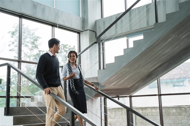 Two colleagues talking on an office staircase
