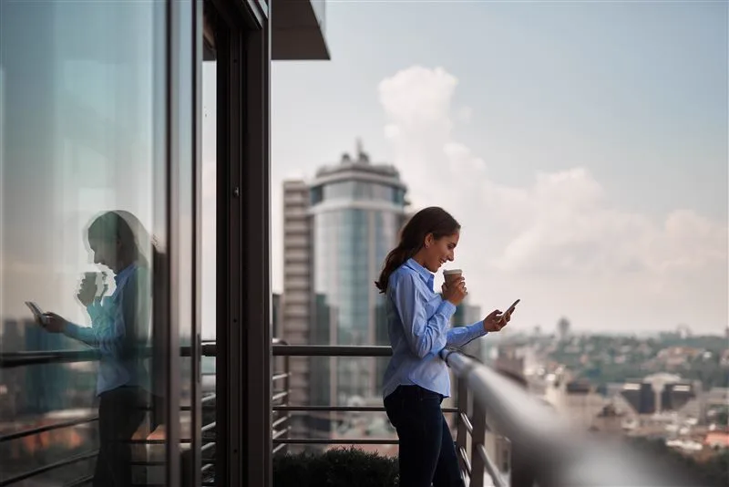 Professional woman on a balcony overlooking a city skyline