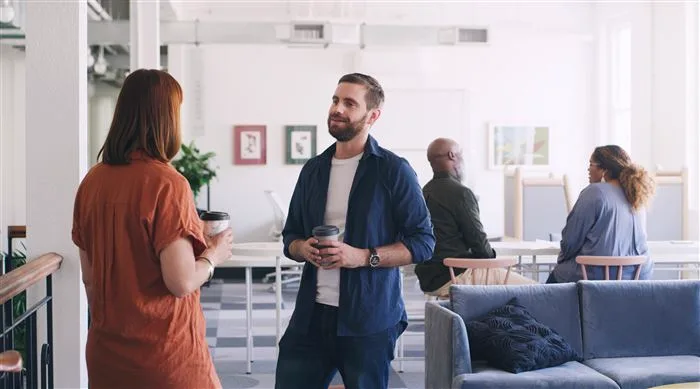 Two colleagues talking in an open-plan office
