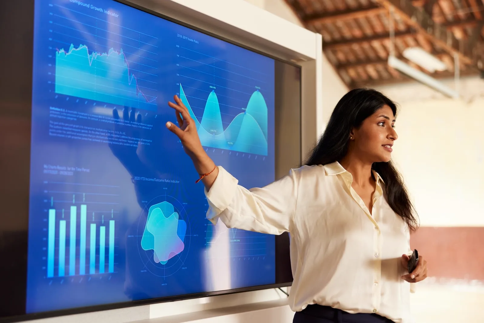 Presenter pointing to charts on a large screen