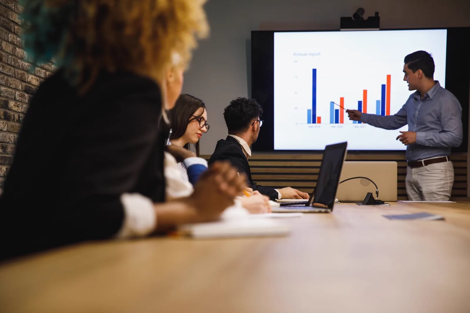 Colleagues reviewing a chart on a screen in a meeting room