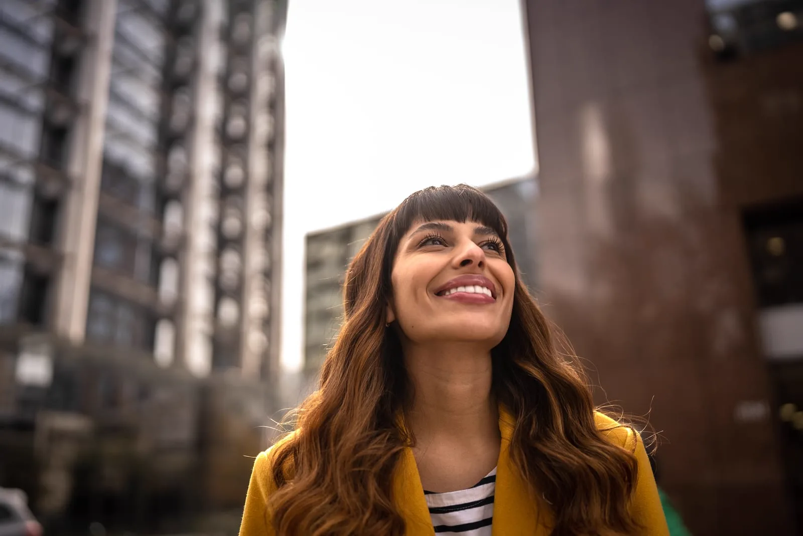 Woman smiling and looking upward in a city street